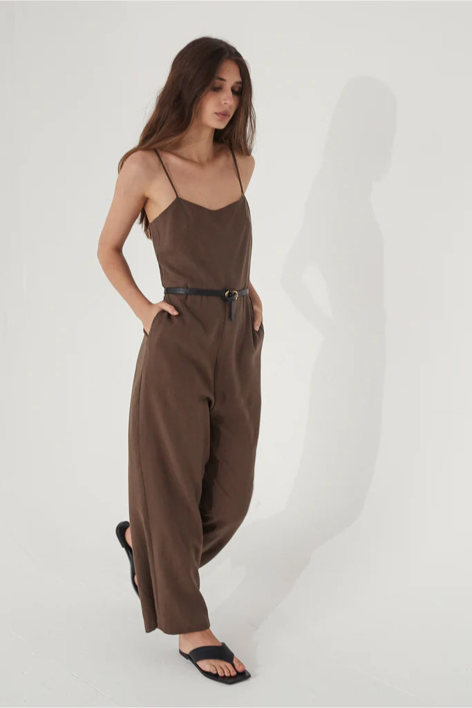 Woman wearing a brown jumpsuit on a white background