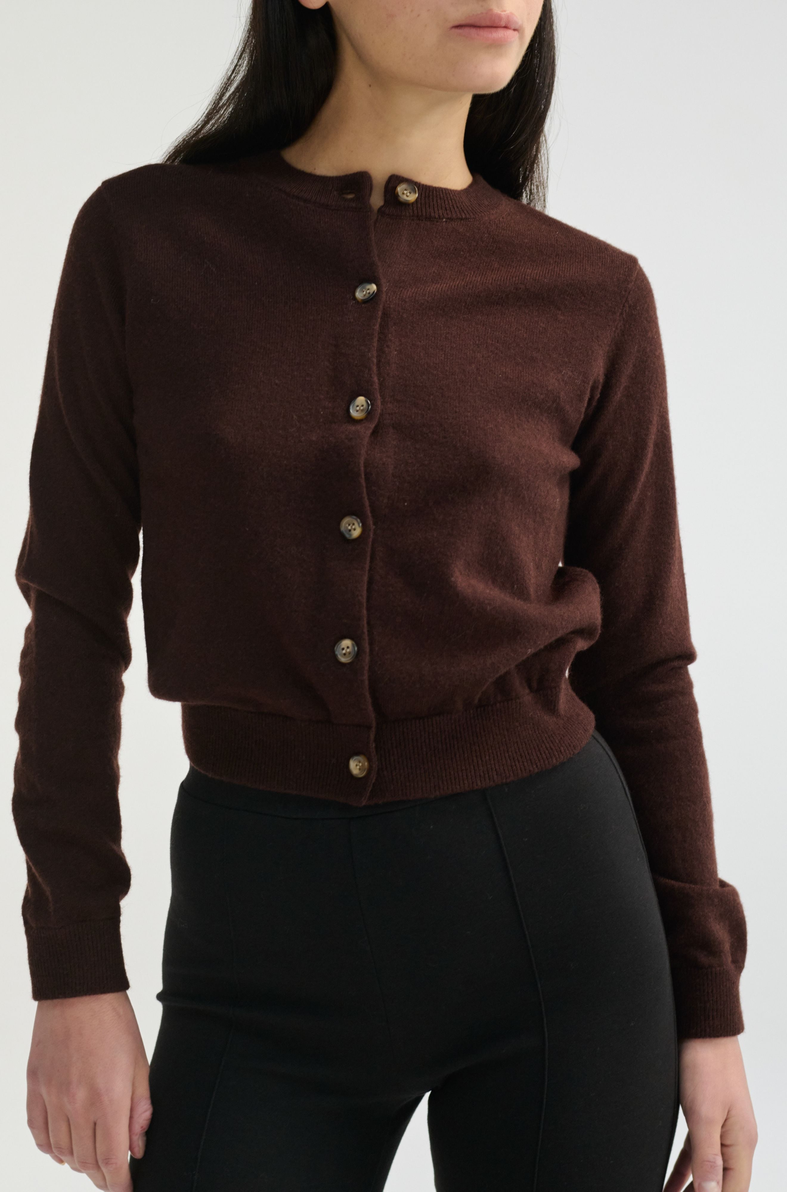 Brown button-up shirt worn by a person on a white background