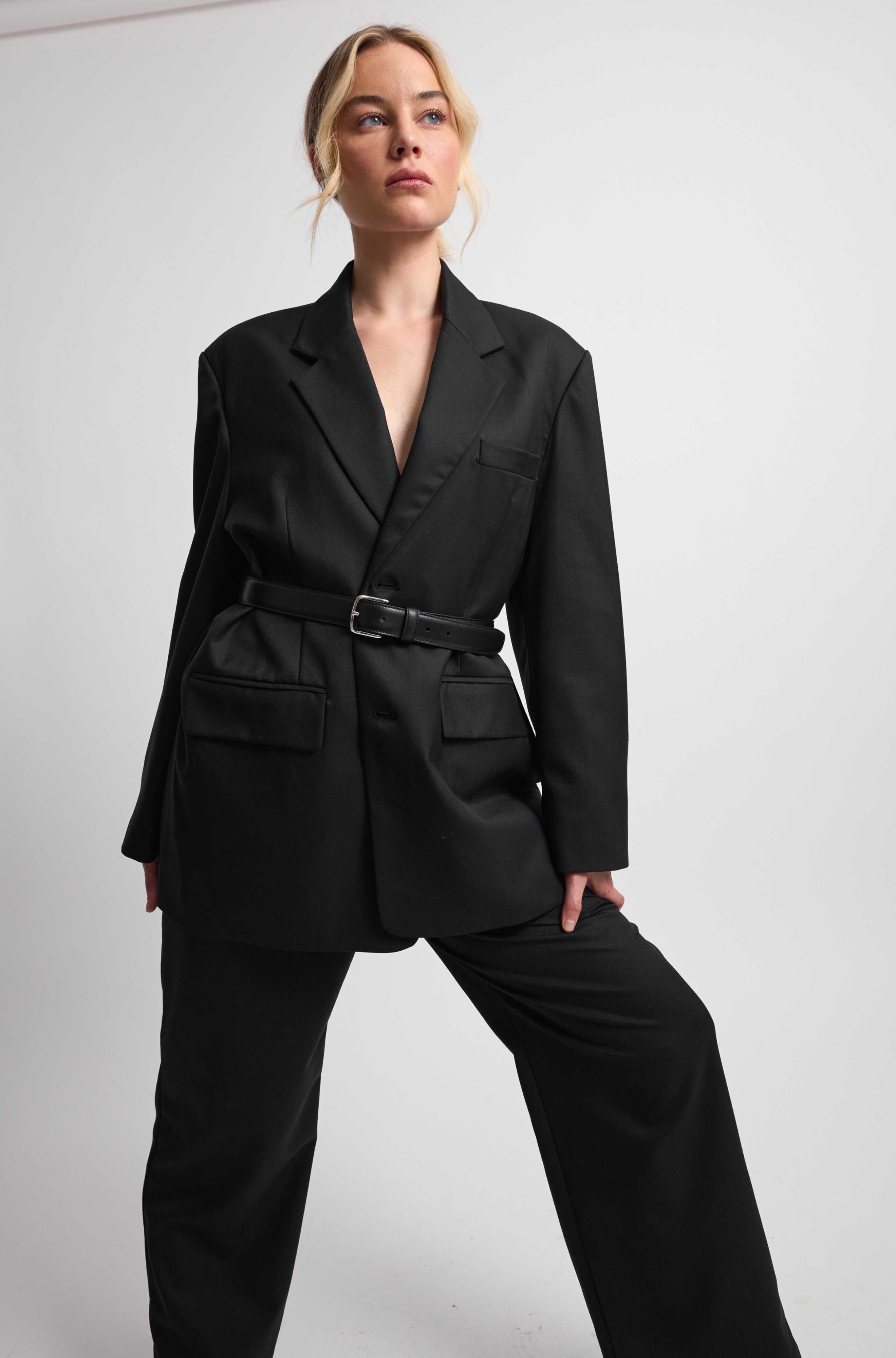 Woman wearing a black suit against a white background