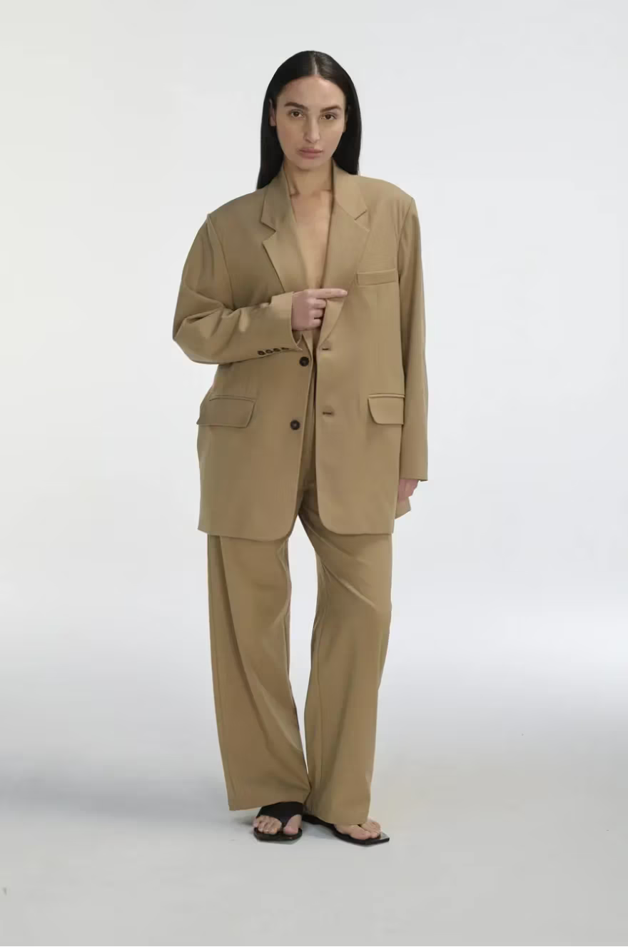 Woman wearing a beige suit on a white background